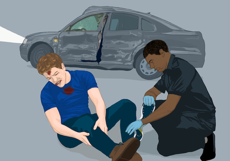A first responder attending to a young man beside a damaged car